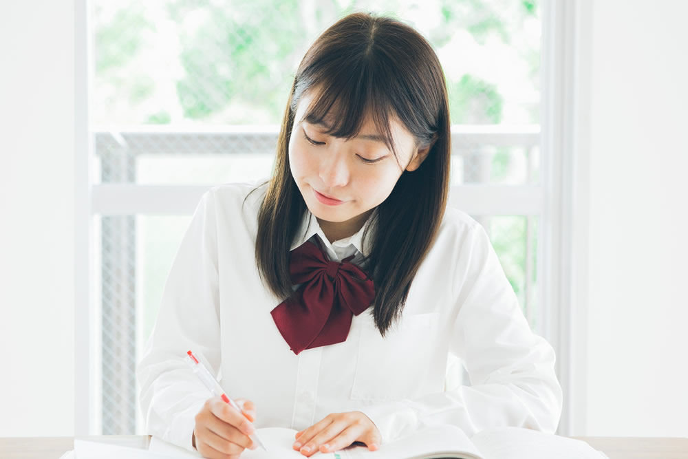 机に向かって勉強をしている中学生