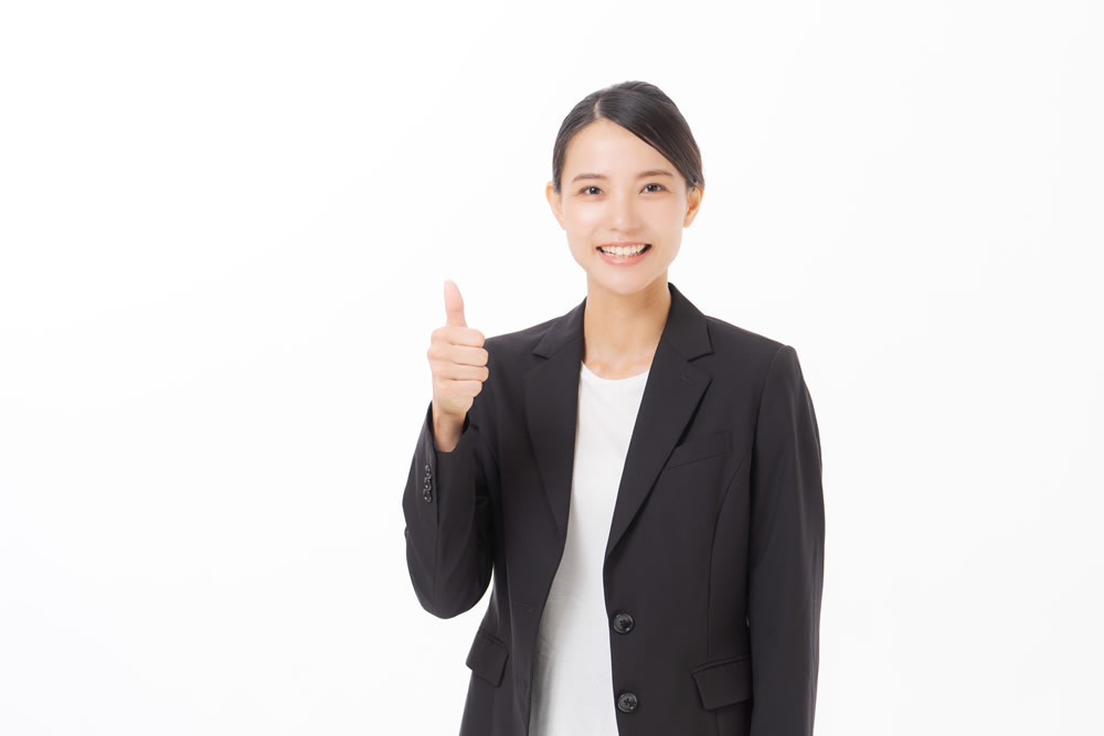 女性の塾講師がグーポーズをしているところ