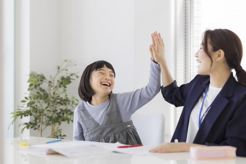 成績がアップして喜んでる生徒と塾の講師